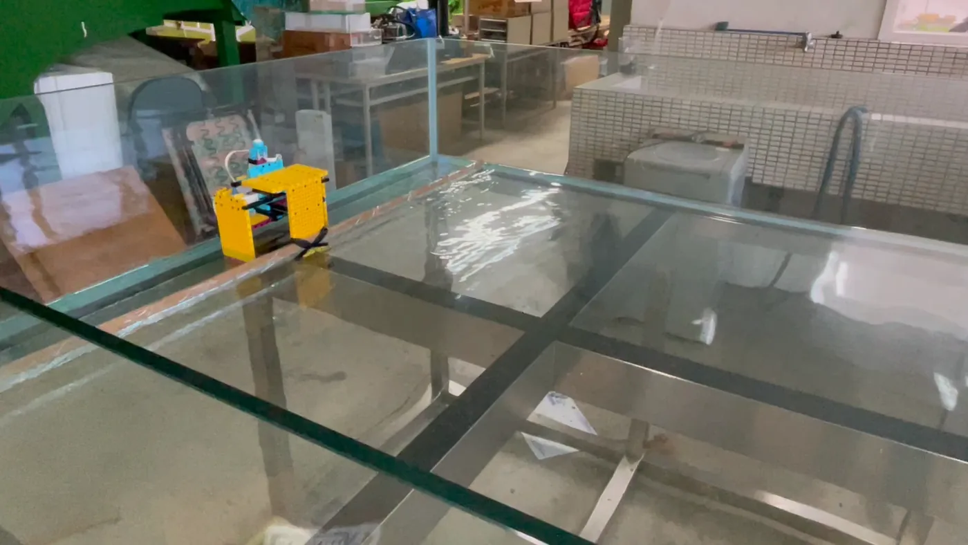 Glass wave basin with a small yellow piston-type wave maker